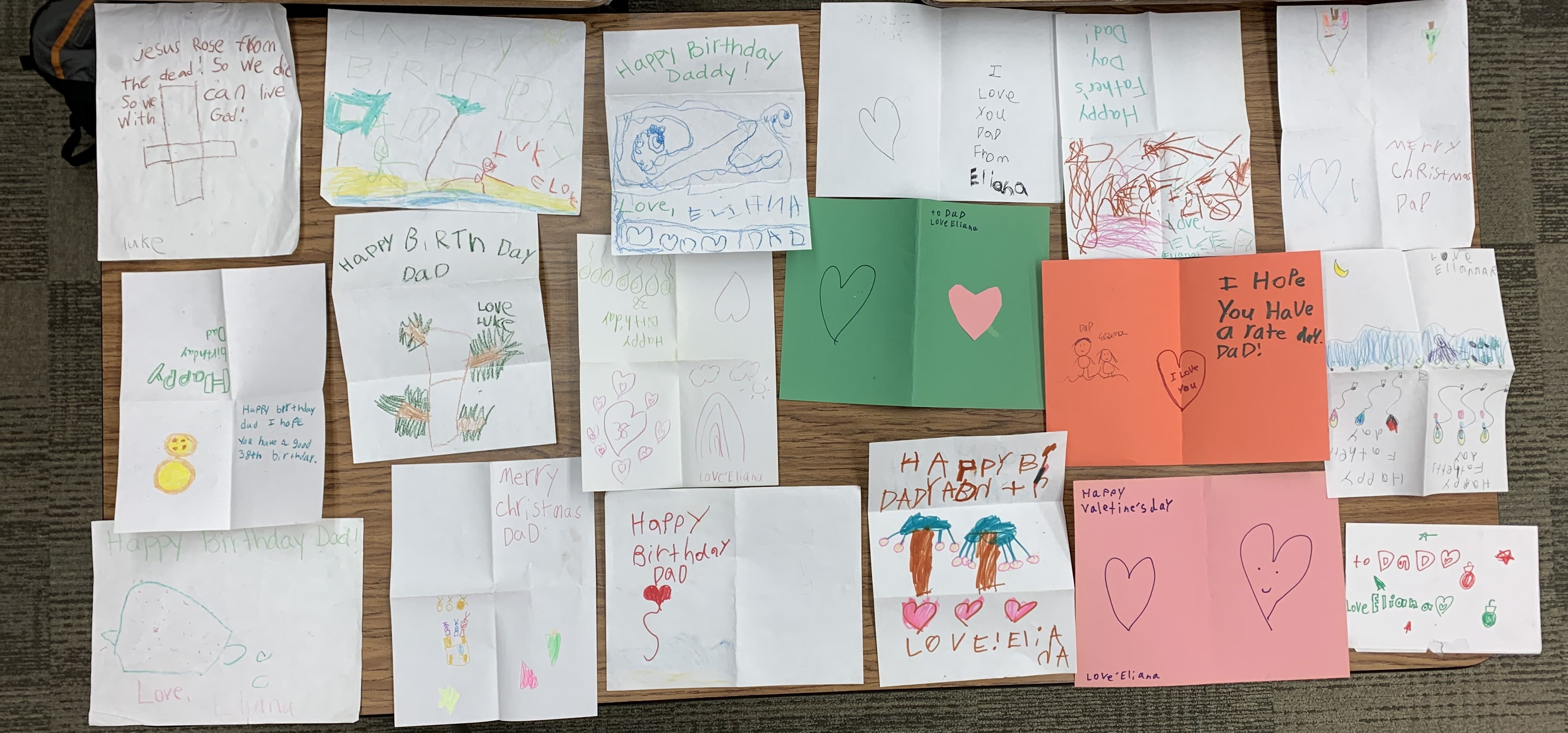 A table covered with handmade cards from my children, collected over more than a decade — birthdays, Father's Day, Christmas, and just-because notes.