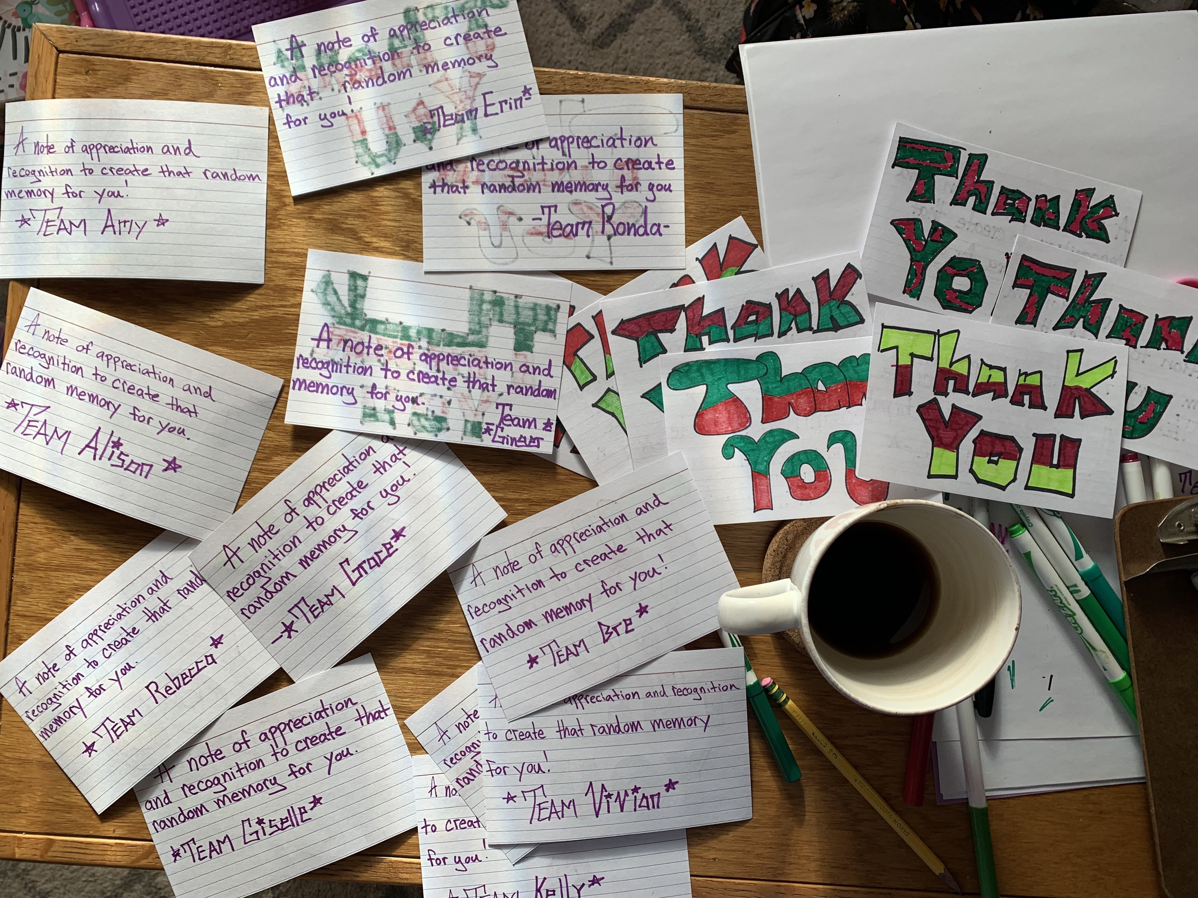 A table of handwritten thank-you notes — 'a note of appreciation and recognition to create that random memory for you' — named for each team, beside hand-lettered THANK YOU cards and a cup of coffee.